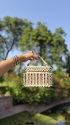 Detailed close-up of the hand-stitched glass bead borders and pearls on the Adira bag.
