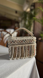 The Adira bag styled with a white blazer, highlighting its dual handle and strap versatility.