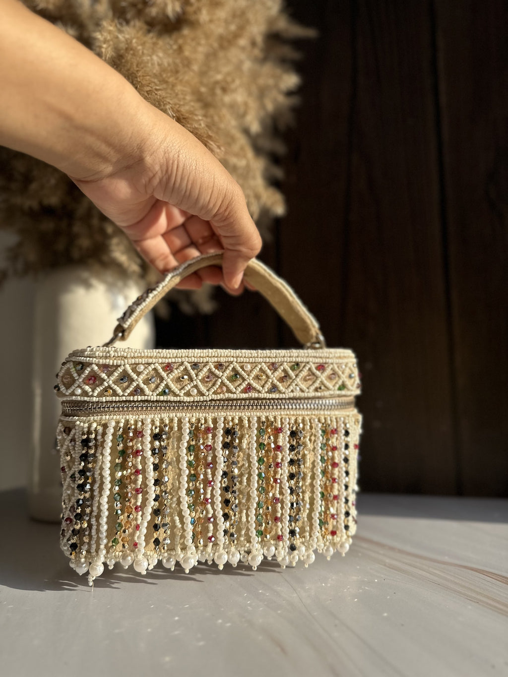 Close-up of the metal clasp attachment and the textured bead pattern on the side panel.