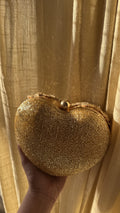 Front view of the Amour Heart Beaded Clutch, showcasing its red and pink glass beads and gold frame lock.