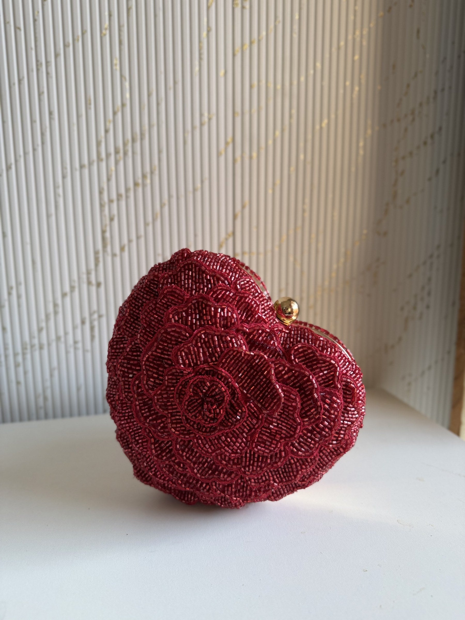 The Amour heart bag open, displaying the soft red satin lining and compact main compartment.