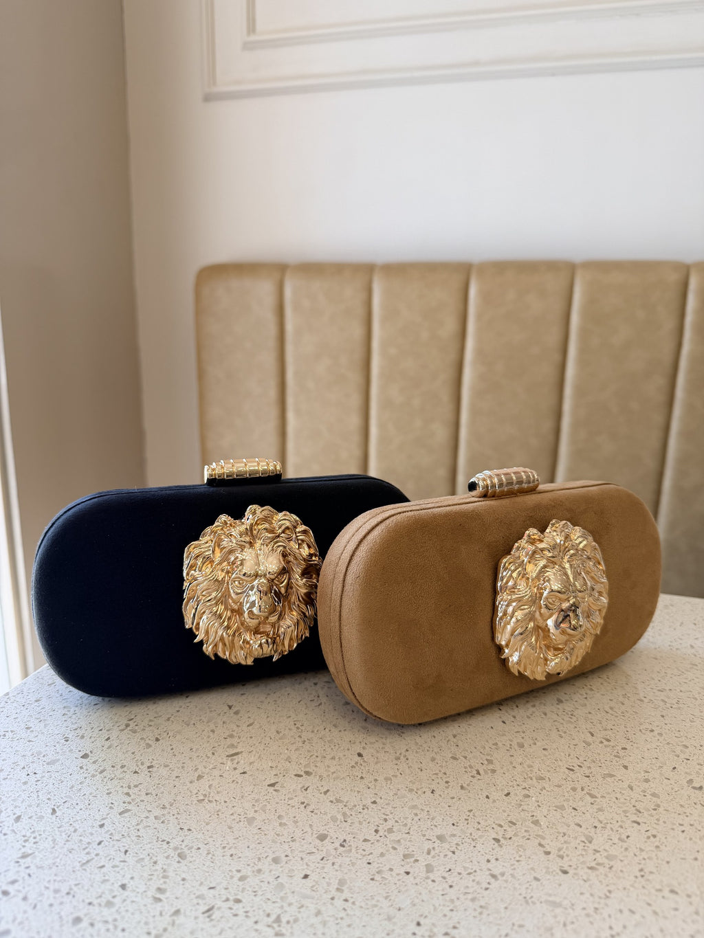 Detailed close-up of the polished gold border clasp lock on the Aurelia clutch.