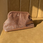 The Aurelle gold clutch styled with a red Banarasi saree, demonstrating wedding day elegance.