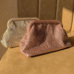 The Aurelle clutch open, displaying fit capacity for an iPhone Pro Max and accessories.