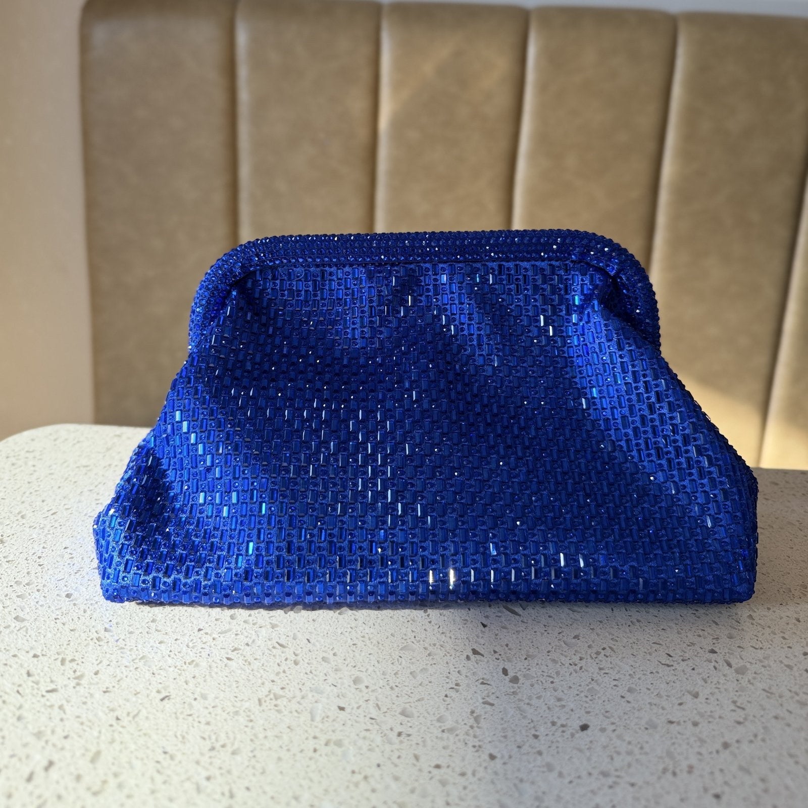 The Aurelle bag hanging on a display stand, highlighting its high-end hardware finish.