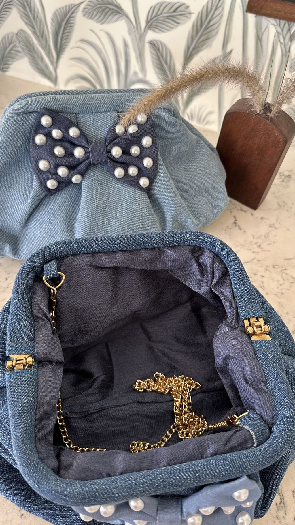 Lifestyle shot of the Belle Bow bag styled with a white linen dress for a weekend outing.