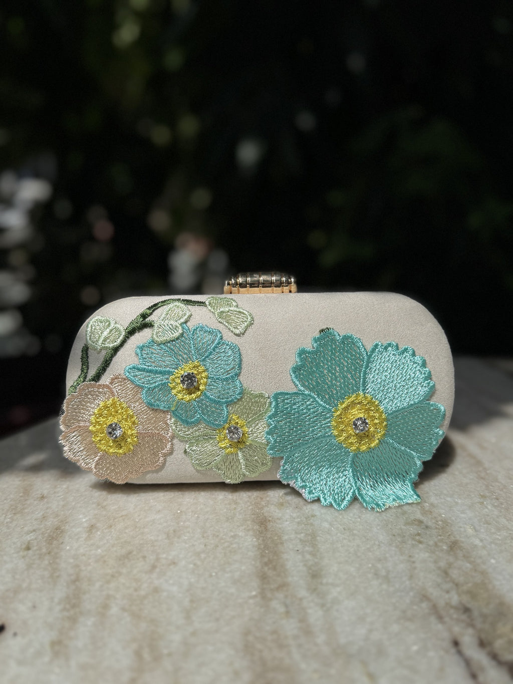 Front view of the Bloom Box clutch, showing the details of the embroidered blossoms.