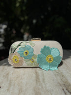 Front view of the Bloom Box clutch, showing the details of the embroidered blossoms.