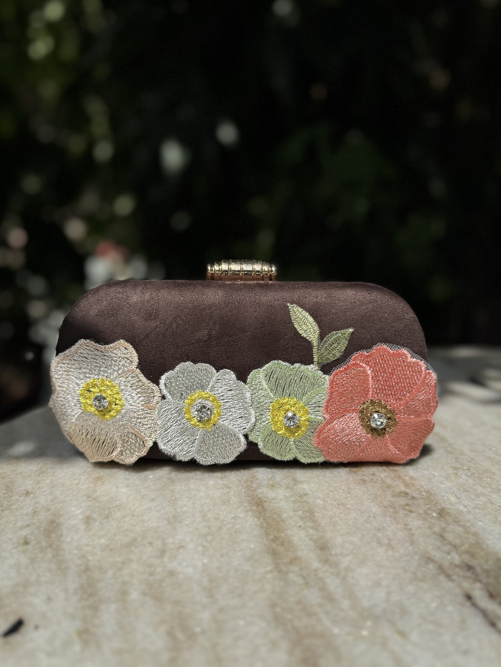 Side profile of the Bloom Box clutch, illustrating its structured rectangular depth.