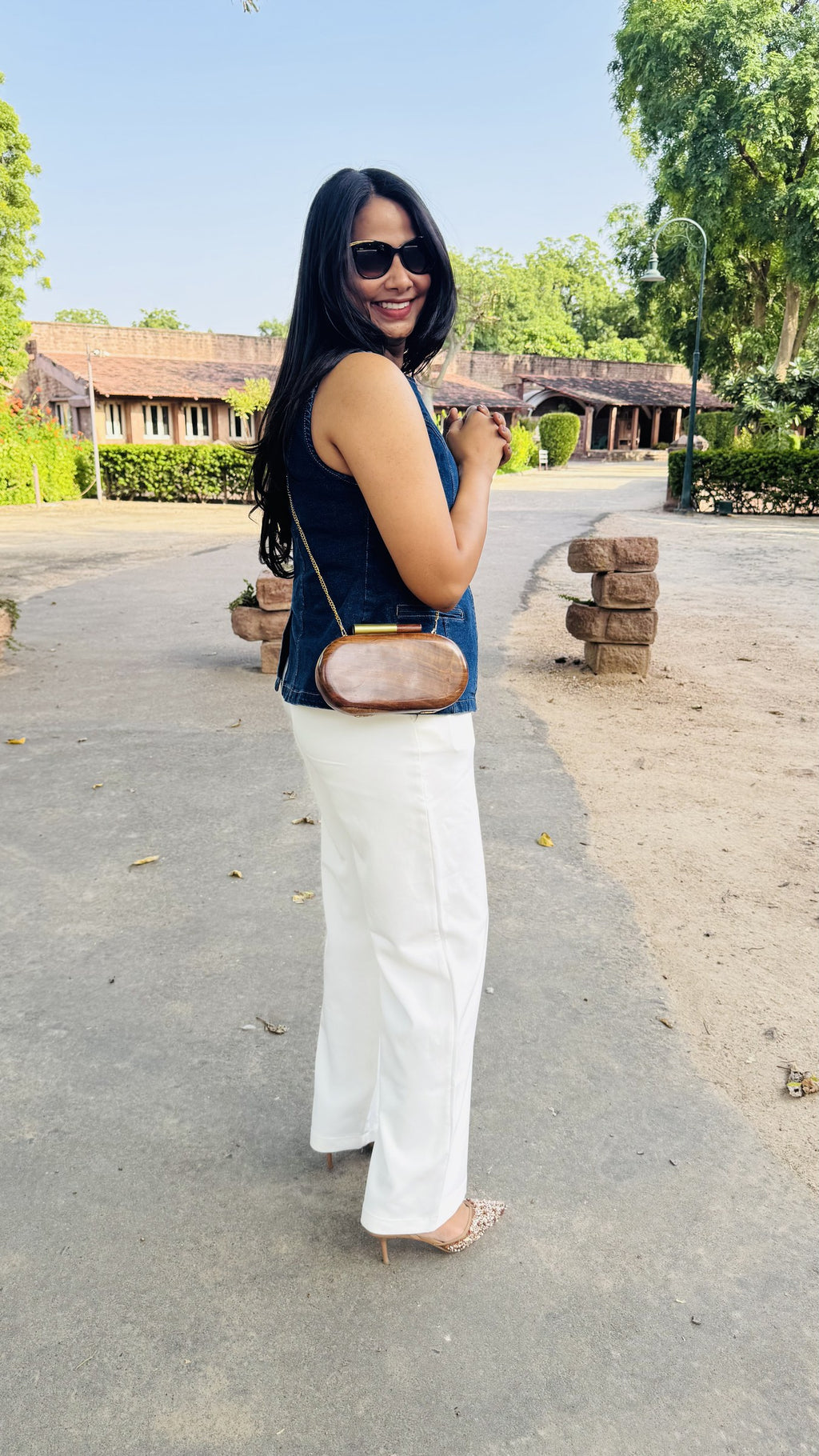Model styling the Capsule Wooden clutch handheld with traditional ethnic wear.