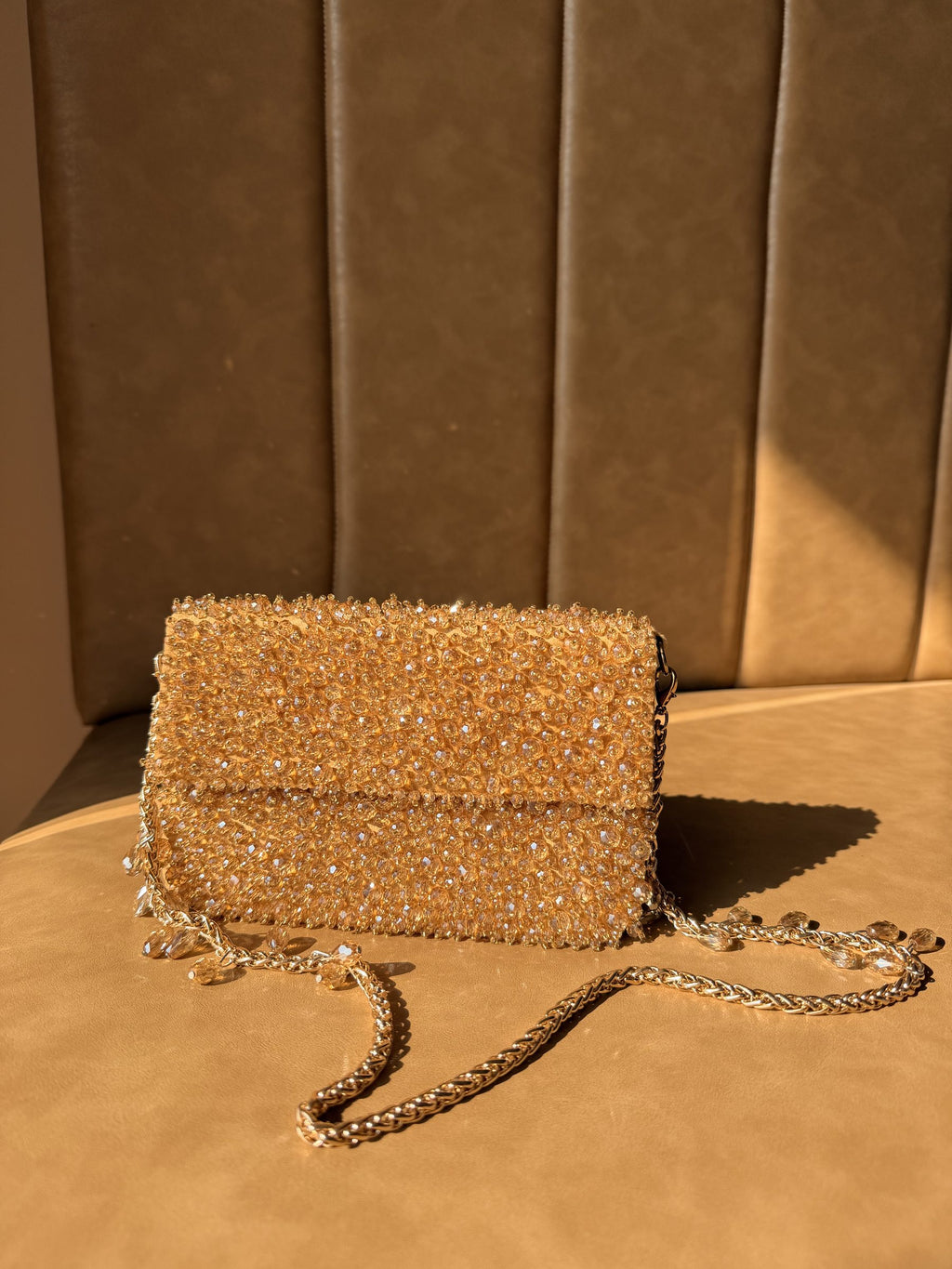 Front view of the Celebration Capsule Pearl Clutch in warm beige, showcasing the rows of hand-embellished pearls.