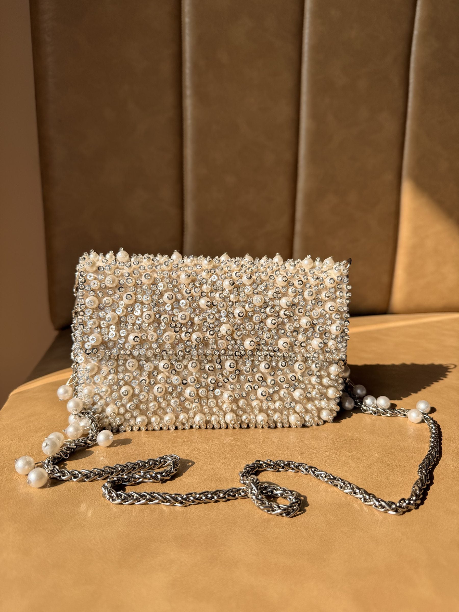 Side angle of the Celebration Capsule clutch showing its slim profile and gold clasp.