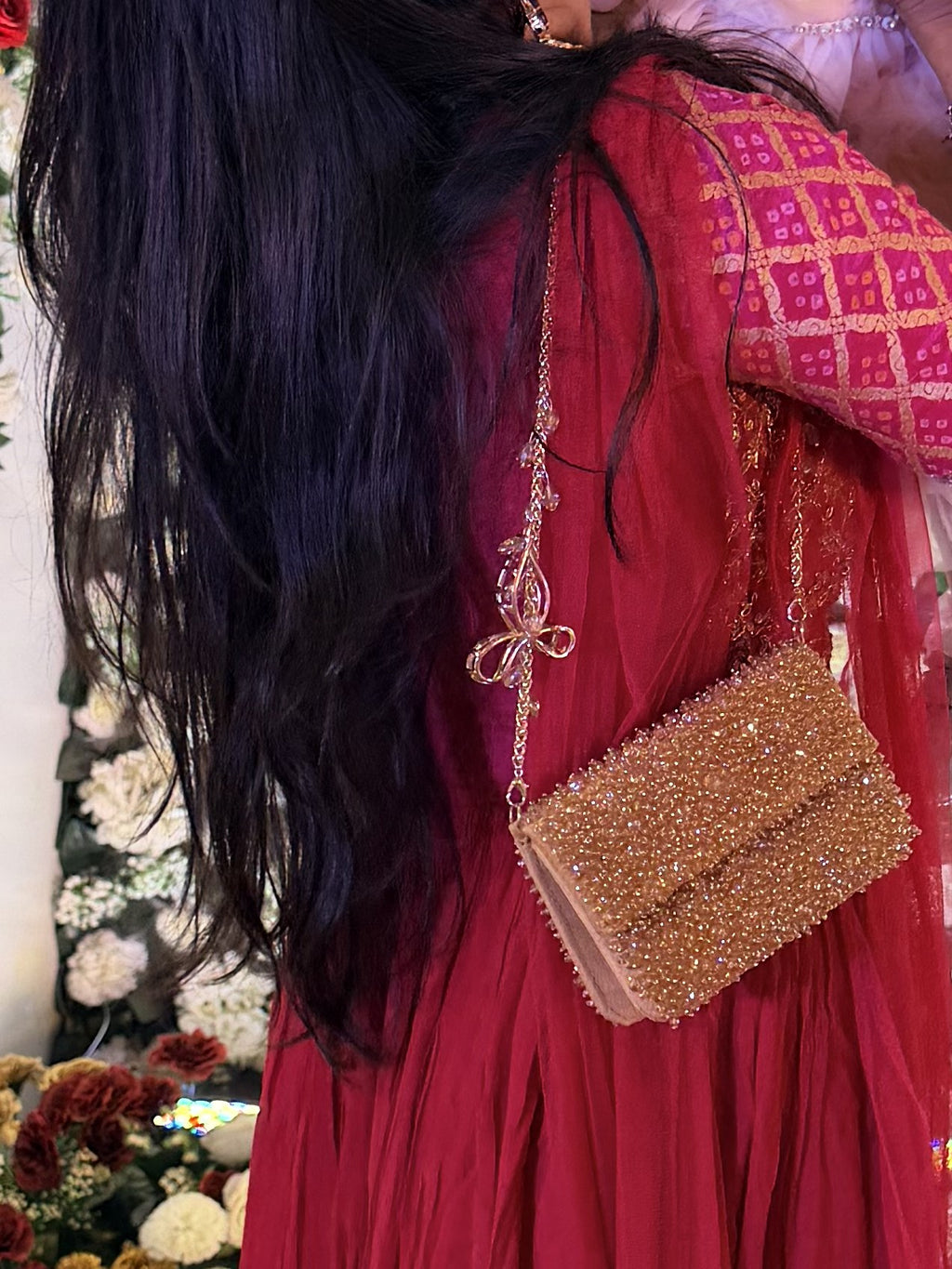 Model carrying the Celebration Capsule clutch handheld, illustrating its elegant size.