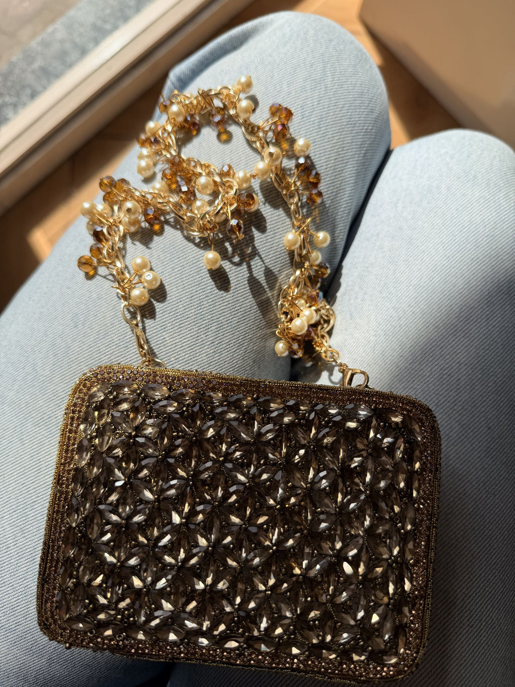 The Champagne Crush mini bag styled handheld, showing its small scale next to evening wear.