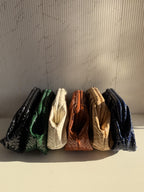 Criss Cross cloud bag in white fabric showing red and green criss-cross patterns and metallic sling chain.