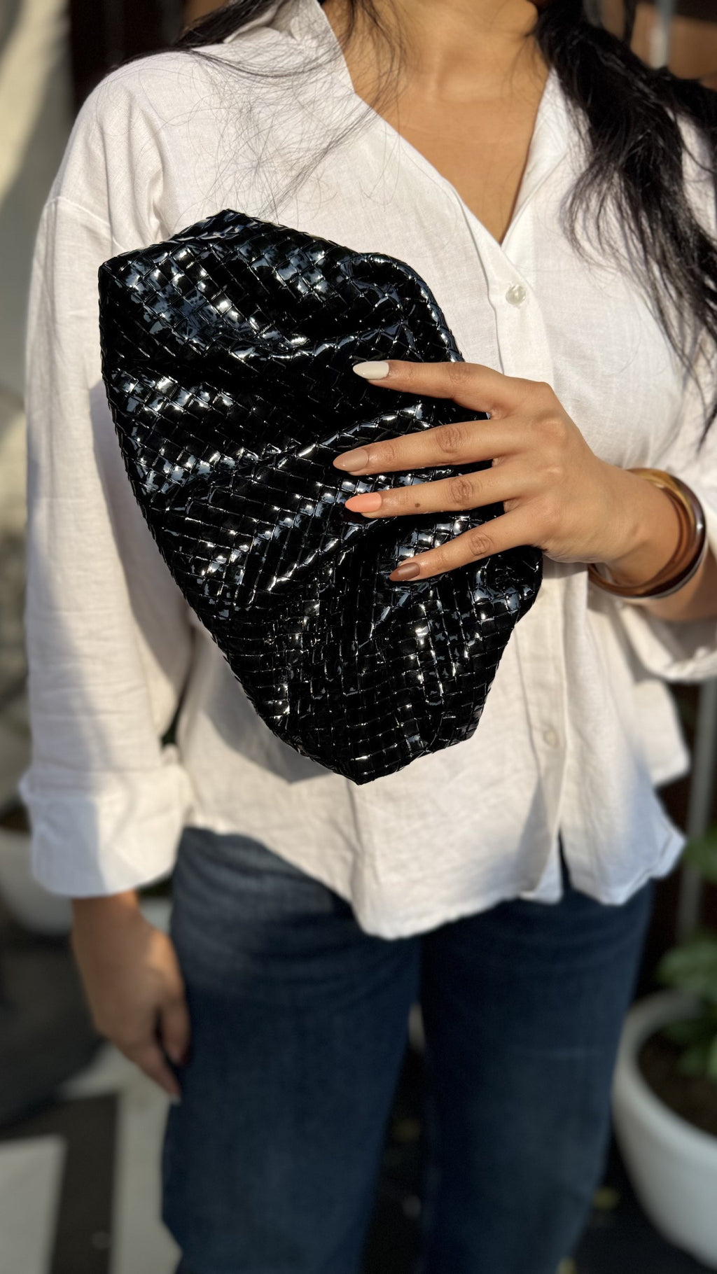 Sling chain laid out next to the bag highlighting its premium metallic finish.