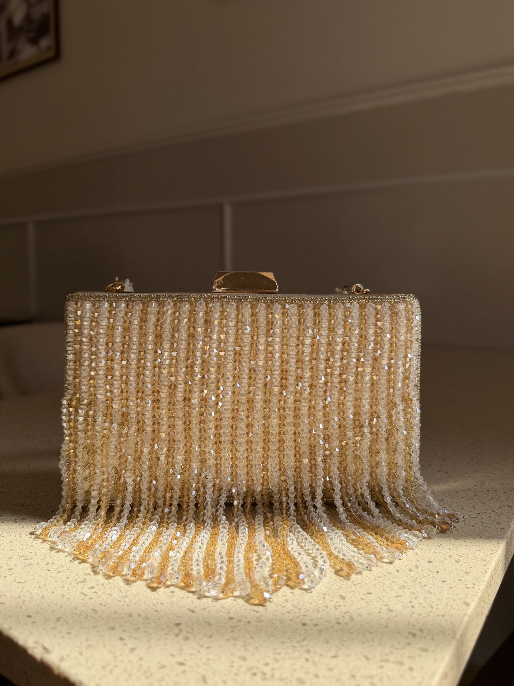 Detailed close-up of the clear crystal fringes dangling from the black satin base.