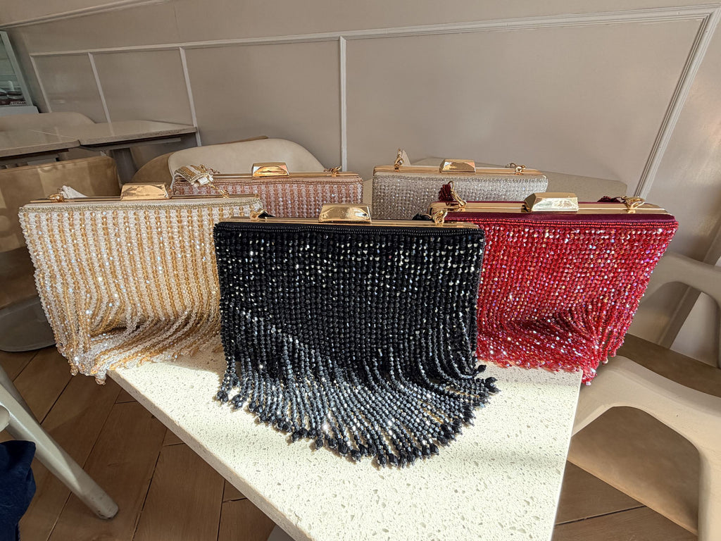 Open view of the Crystal Fringe handbag showing the fabric-lined interior and secure snap closure.