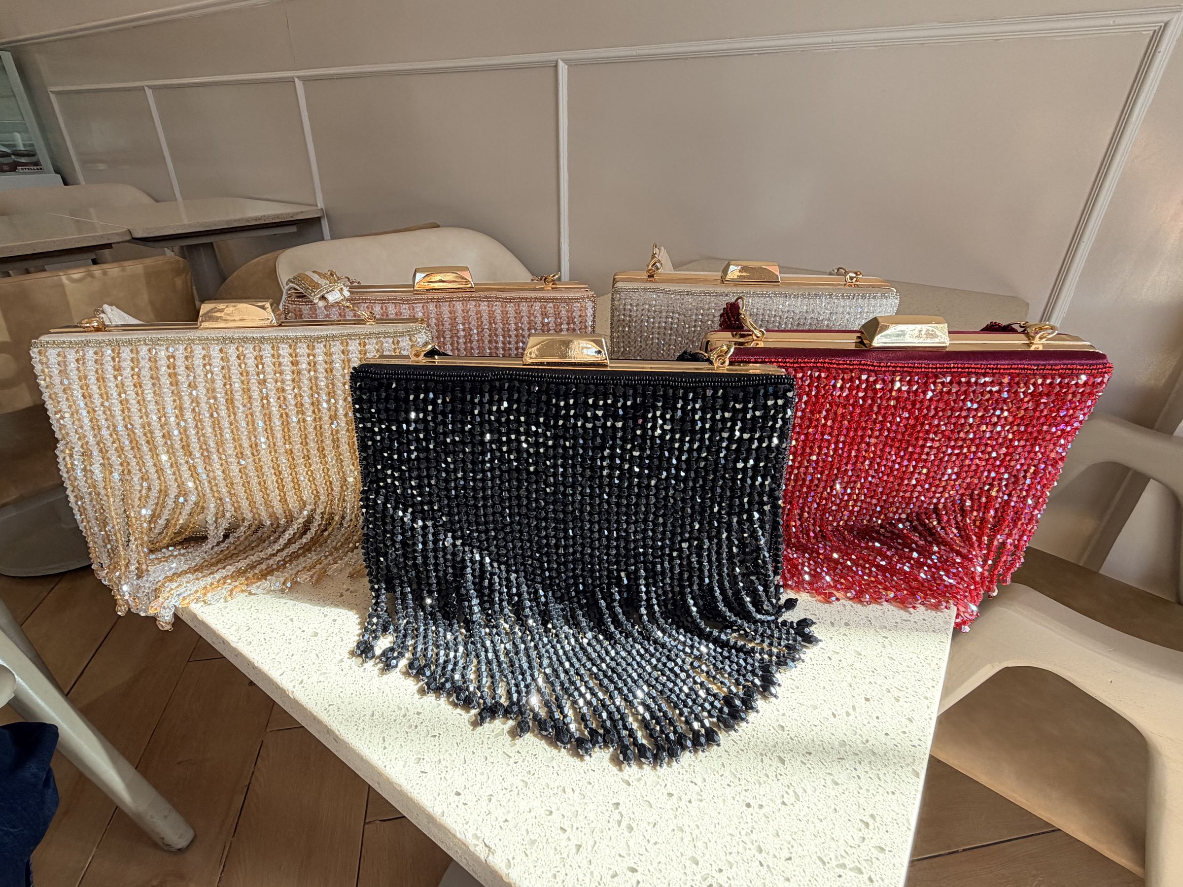 Open view of the Crystal Fringe handbag showing the fabric-lined interior and secure snap closure.