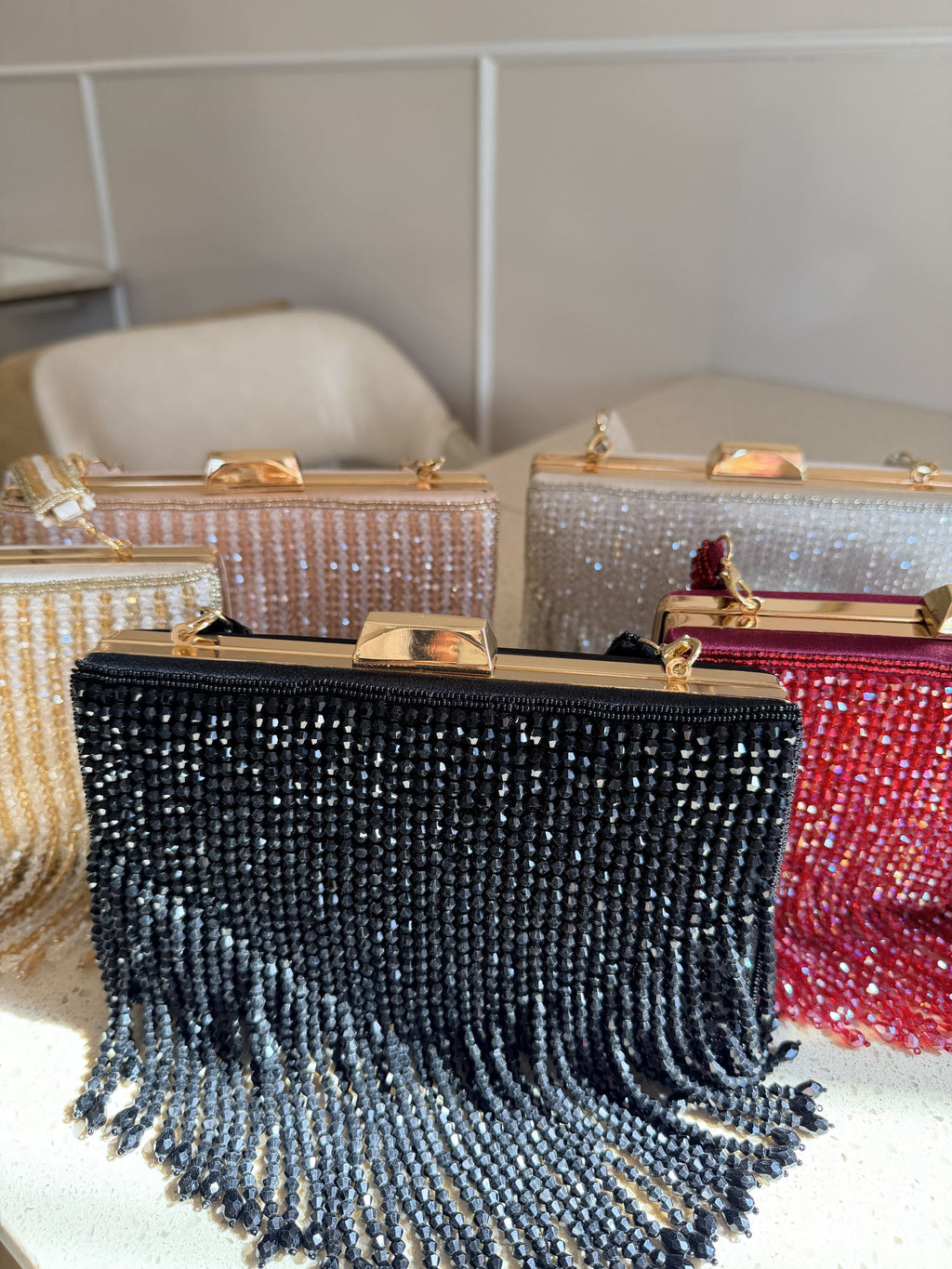 The Crystal Fringe clutch held handheld, highlighting the movement of the crystal tassels.