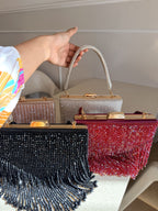 Lifestyle layout of the Crystal Fringe clutch next to cocktail wear and diamond jewelry.