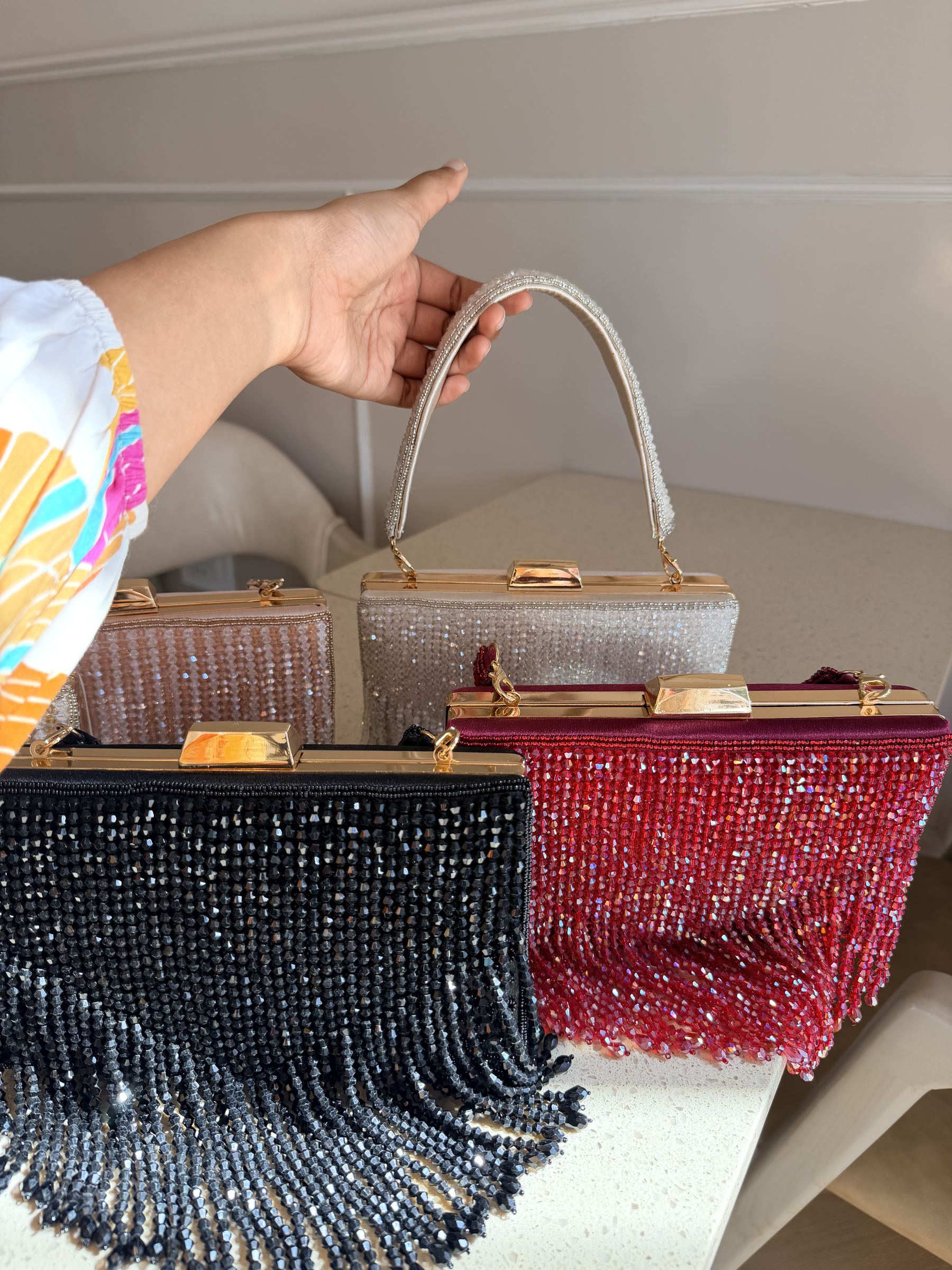 Lifestyle layout of the Crystal Fringe clutch next to cocktail wear and diamond jewelry.