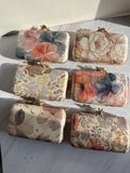 Eight-by-Four digital print clutch showing its multicolored abstract art panel and gold clasp.