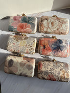 Eight-by-Four digital print clutch showing its multicolored abstract art panel and gold clasp.