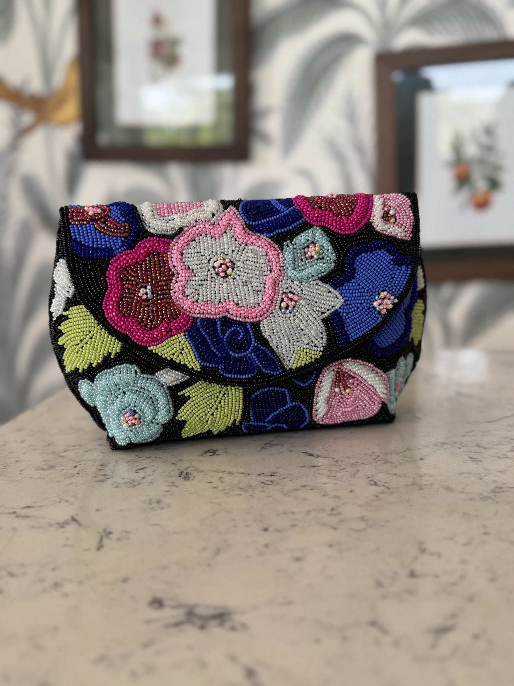 Front view of the Flora Fiesta Beaded Bag, showing the colorful hand-sewn floral motifs and beaded handle.