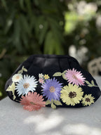Detailed close-up of the delicate floral embroidery on the pink fabric surface.