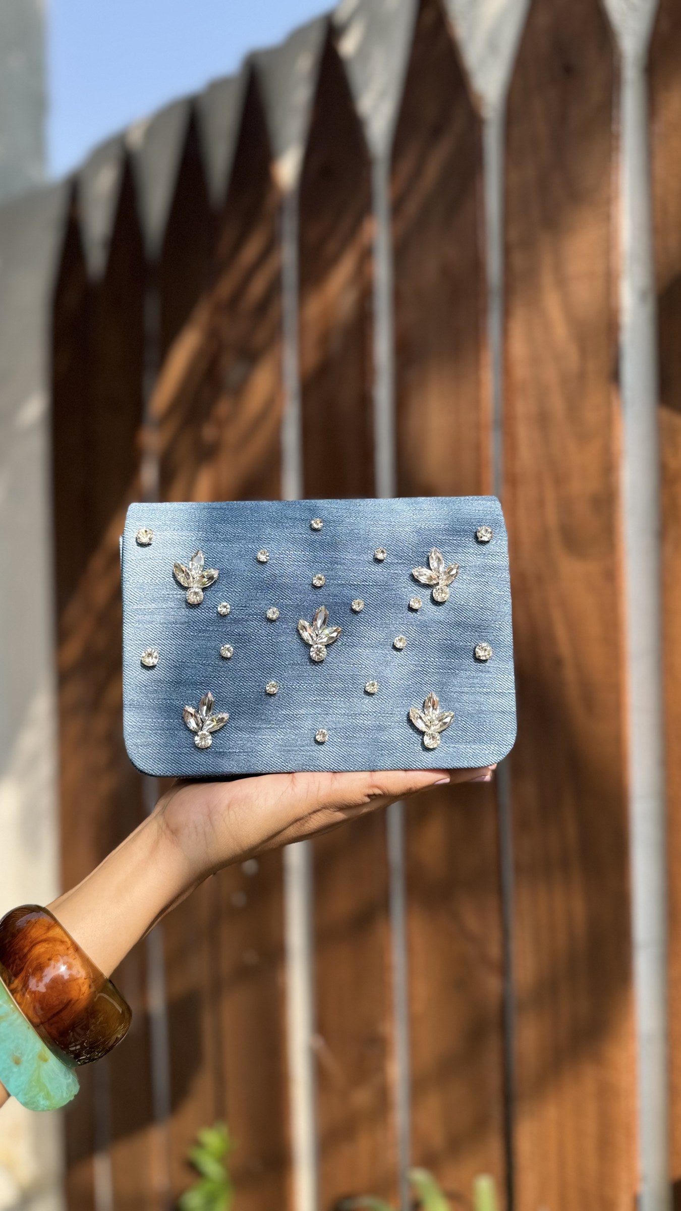 Back view of the denim sling bag highlighting the smooth, clean pocketless fabric layout.