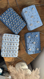 Flat-lay image of the denim sling bag shown with sunglasses, keys, and an iPhone Pro Max to illustrate size.