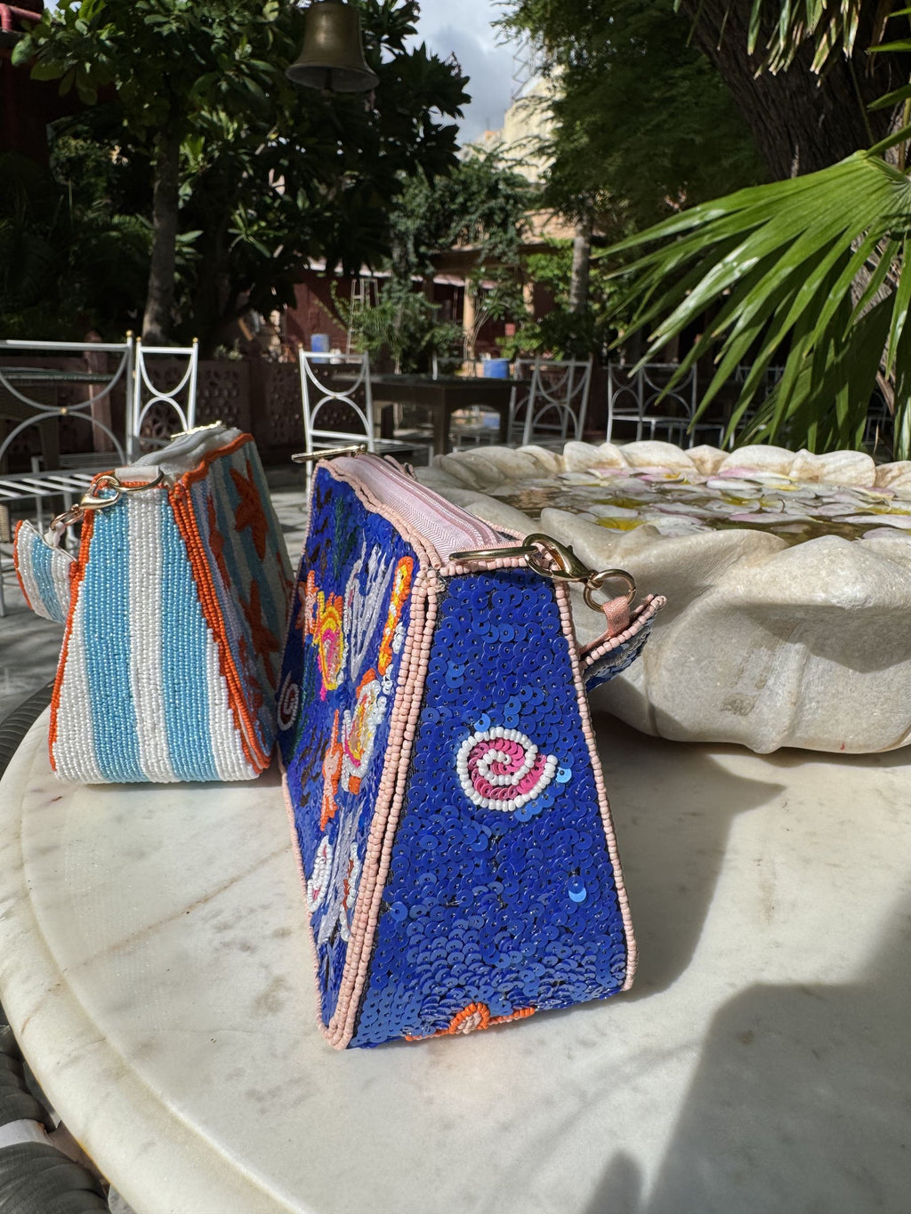 Flat lay of the Funky Fix bag with denim jeans, white sneakers, and sunglasses.