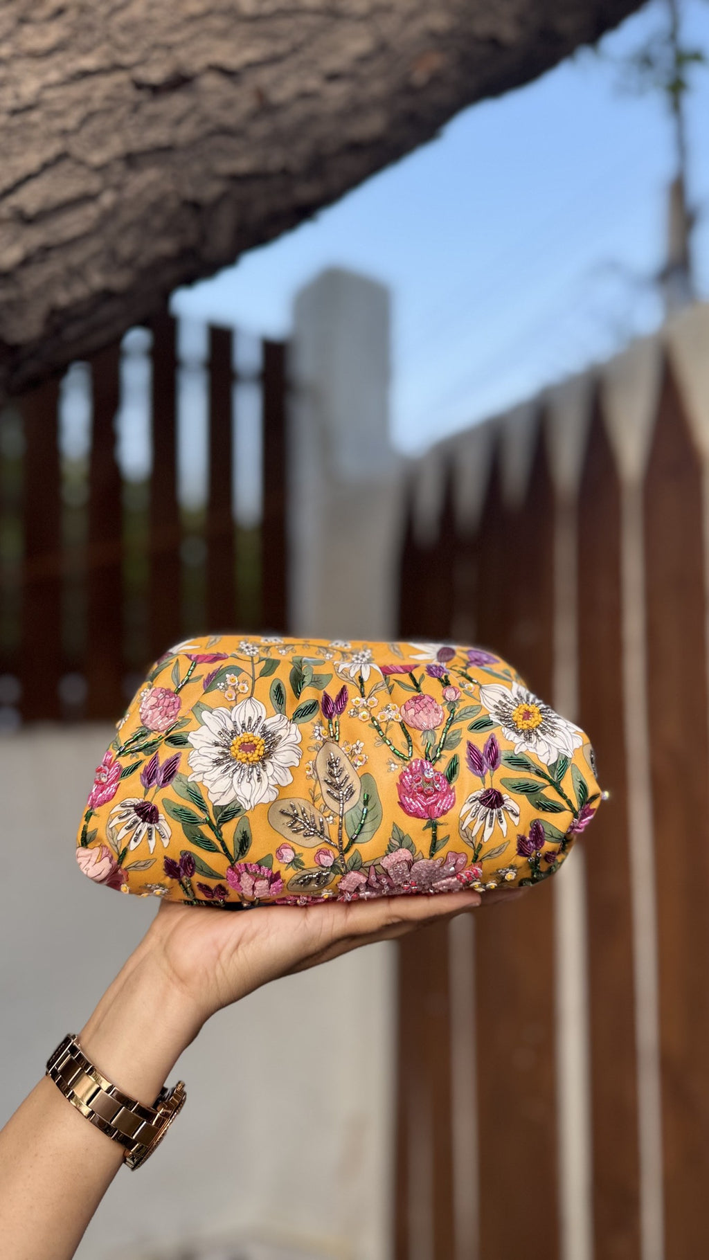 Garden Muse clutch showing the gold sling chain attachment.