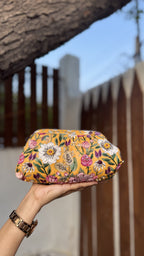 Garden Muse clutch showing the gold sling chain attachment.