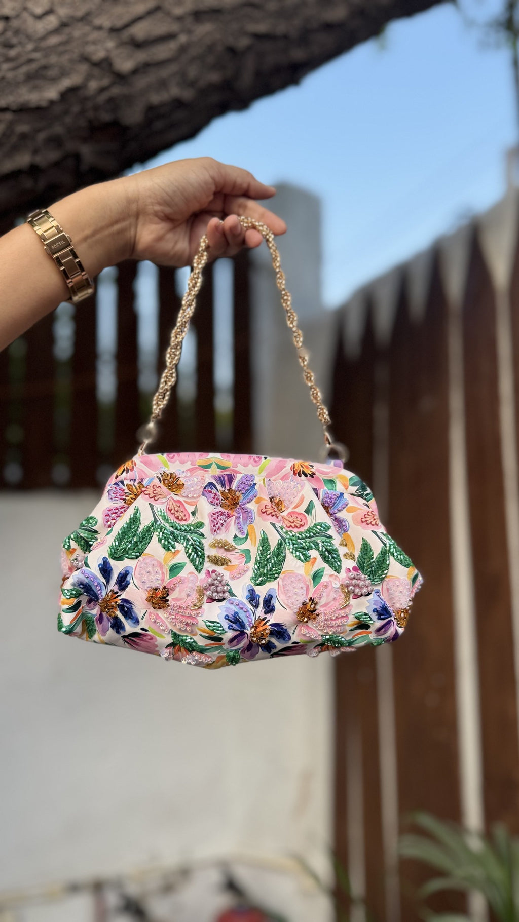 Model styling the Garden Muse clutch with a wedding guest outfit.