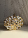 Gilded Muse rectangular brass clutch showing its hand-sculpted gold surface and metal clasp closure.