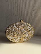 Gilded Muse rectangular brass clutch showing its hand-sculpted gold surface and metal clasp closure.