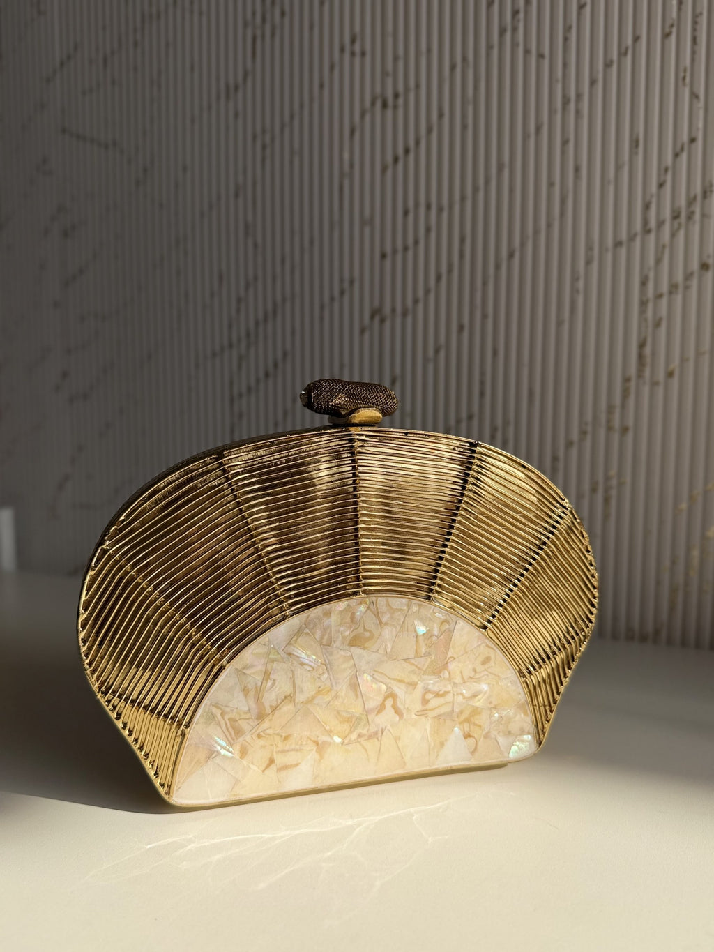 Detailed close-up of the sculpted floral and abstract patterns on the gold brass frame.