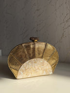 Detailed close-up of the sculpted floral and abstract patterns on the gold brass frame.