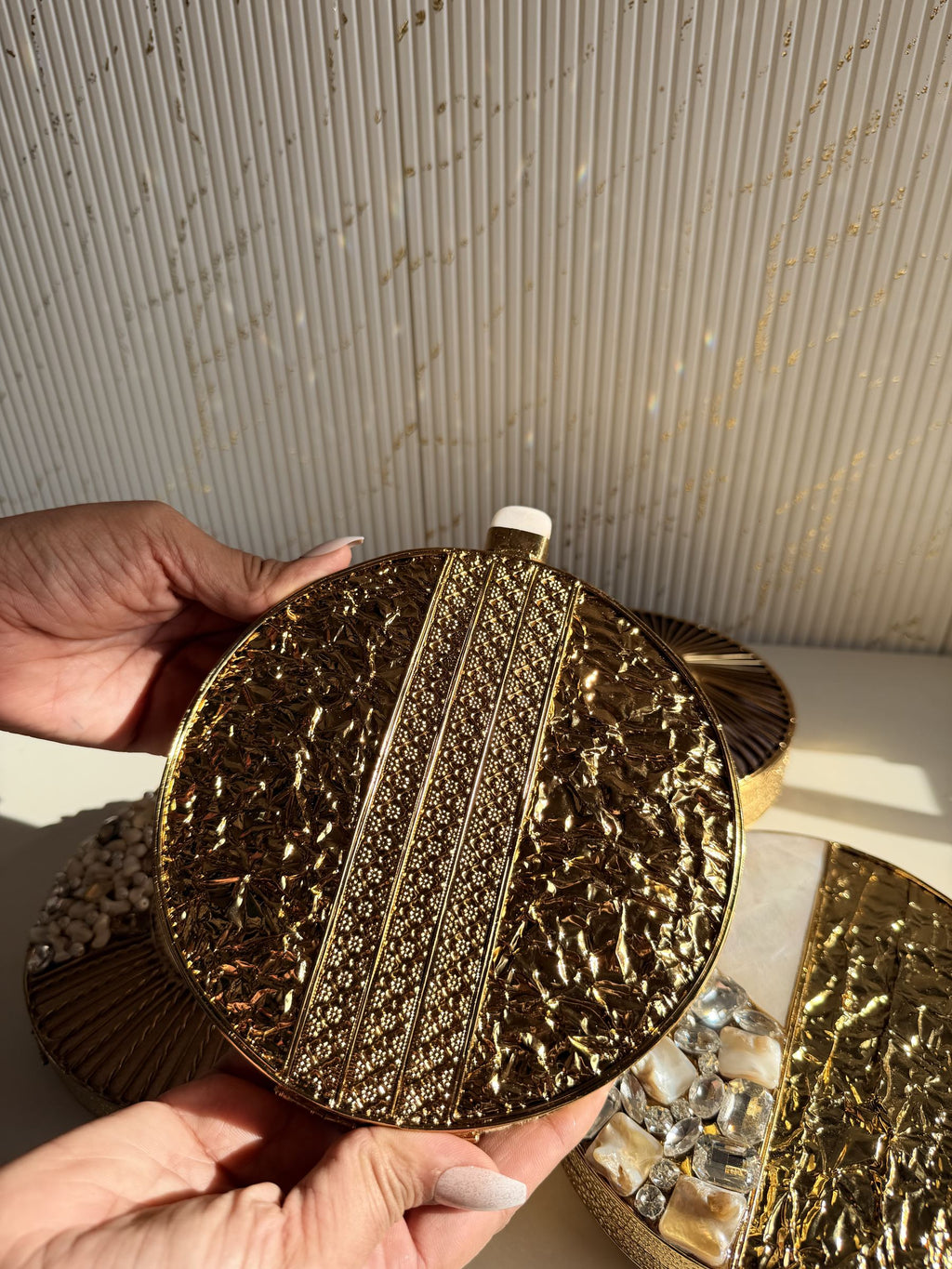 The round brass clutch styled handheld, showcasing its jewel-like design.