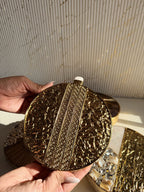 The round brass clutch styled handheld, showcasing its jewel-like design.