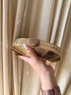 Angle view of the Gilded Muse rectangular clutch, showcasing its classic architectural lines.