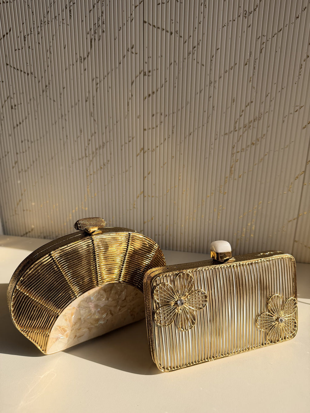 Gilded Muse rectangular clutch held in hand, highlighting its fit for modern smartphones.