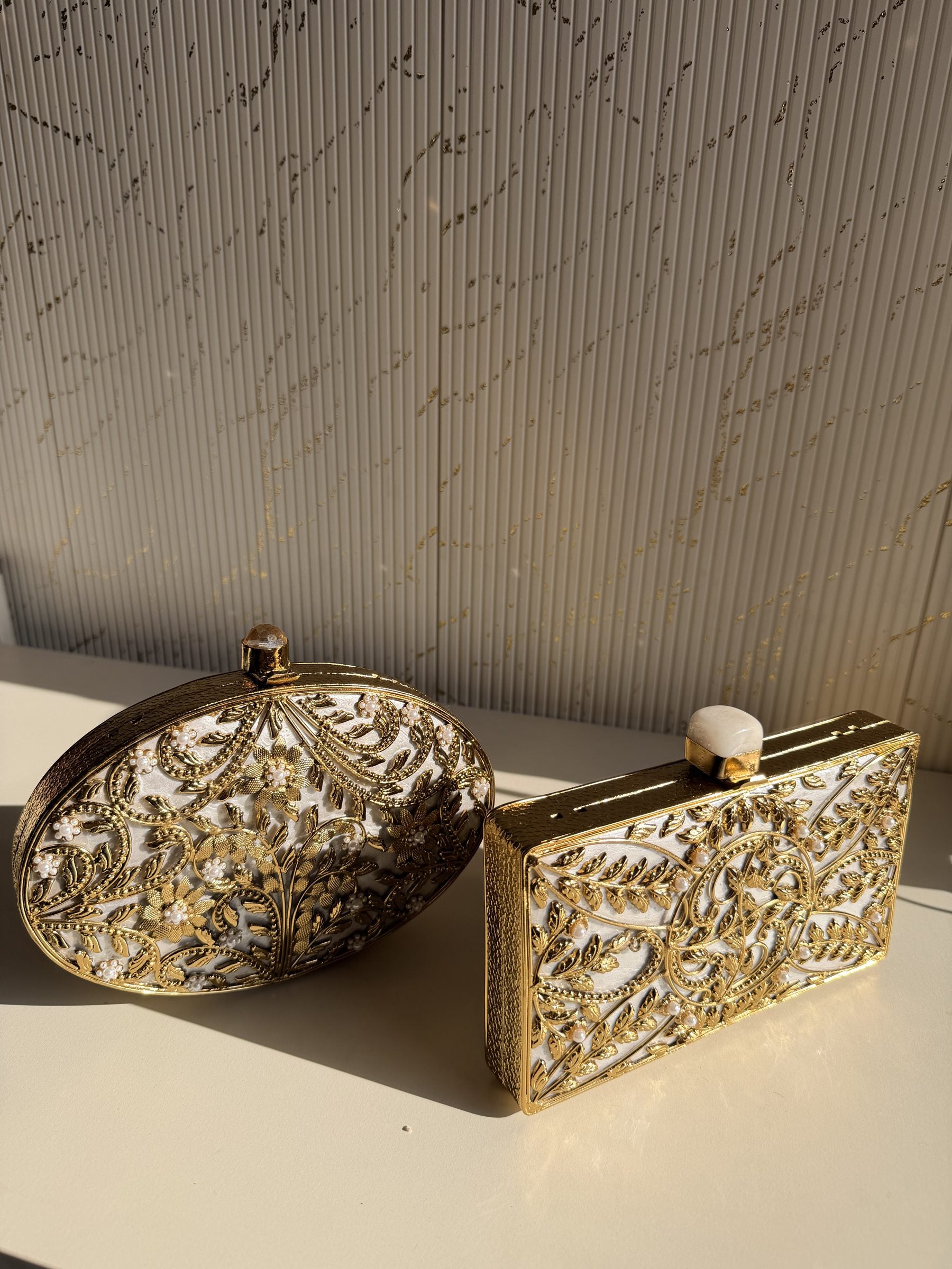 Detailed shot of the gold-tone chain draping next to the polished brass clasp.