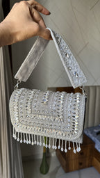 Angled shot of the Glimmer Grip bag, illustrating the gold frame details.