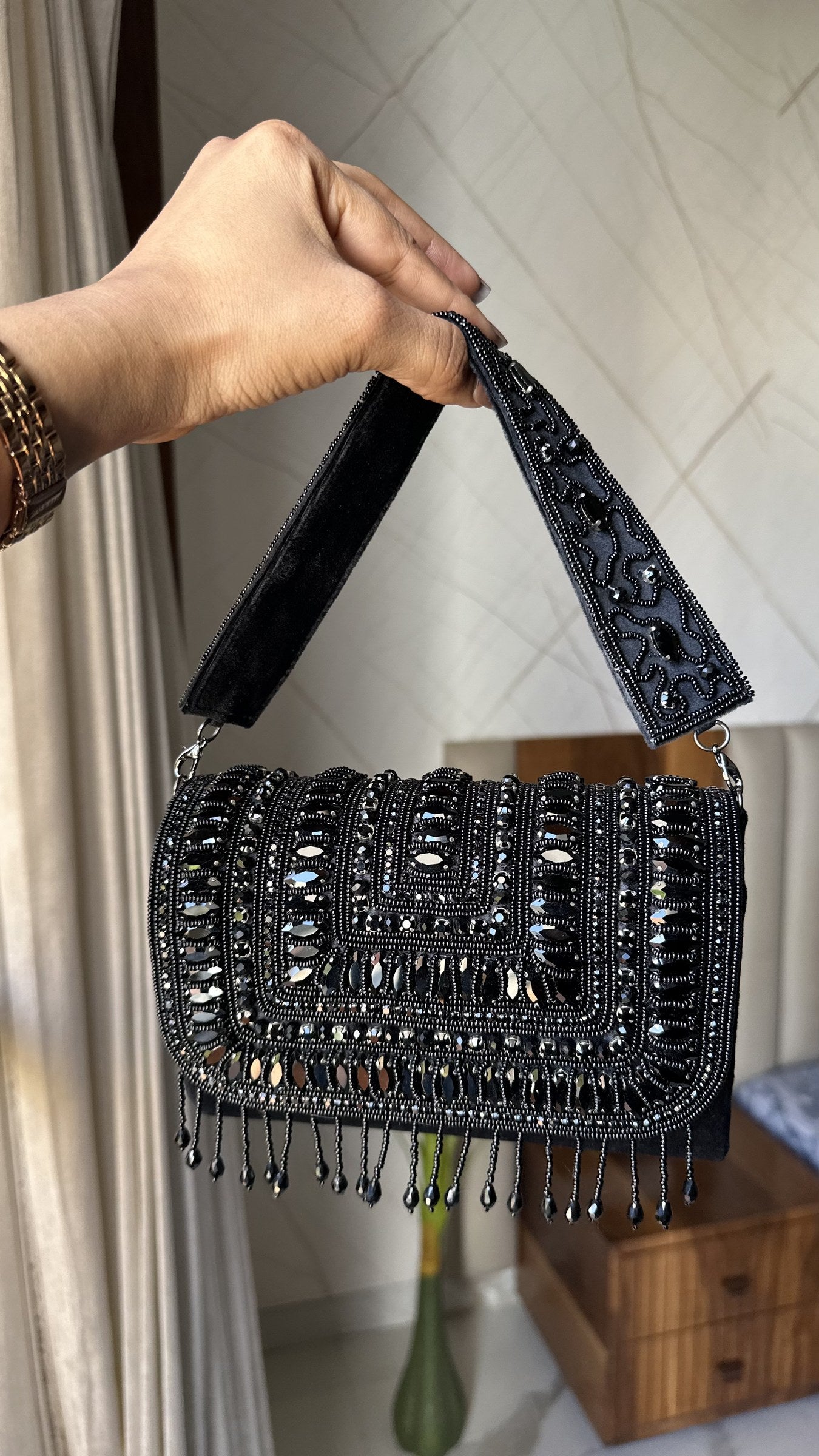Lifestyle layout of the Glimmer Grip clutch next to evening coordinates and champagne.