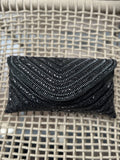 Grainline hand-beaded flap bag in classic white, highlighting its linear bead texture and gold-tone sling chain.
