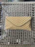 Side angle of the white Grainline flap clutch showing its sleek depth and fabric edge lining.