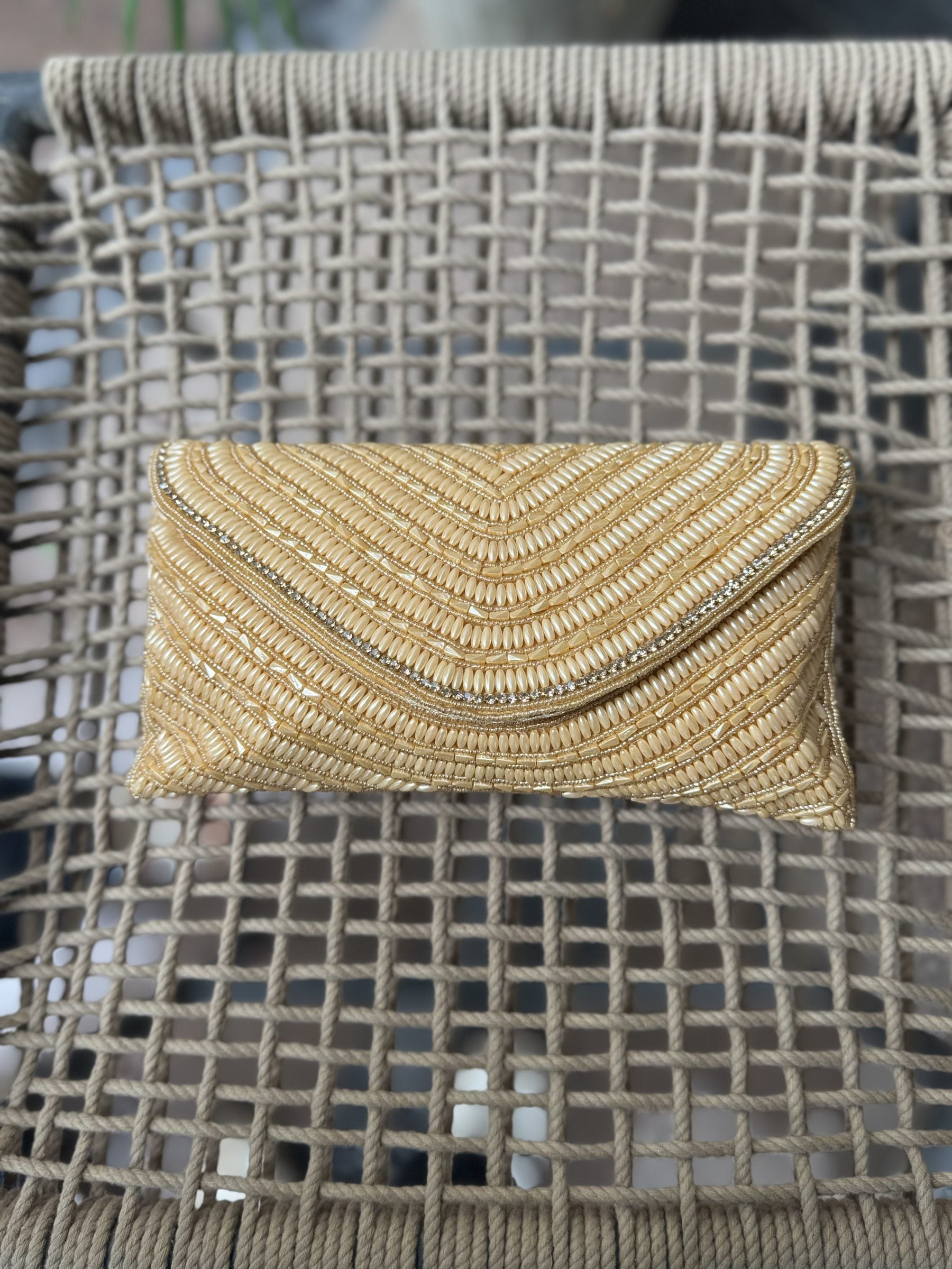 Side angle of the white Grainline flap clutch showing its sleek depth and fabric edge lining.